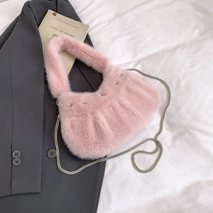 Détail du sac à main en peluche rose avec clous métalliques et bandoulière en chaîne