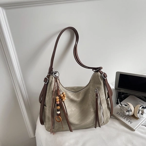 Detailed view of the olive green tote bag featuring wooden bead tassels and leather straps