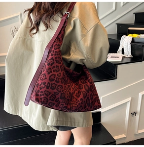 Detail view of the wide leather adjustable shoulder strap on a leopard print tote bag