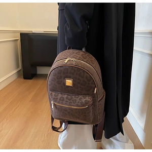Detail view of stylish leopard print backpack with gold zipper and textured surface