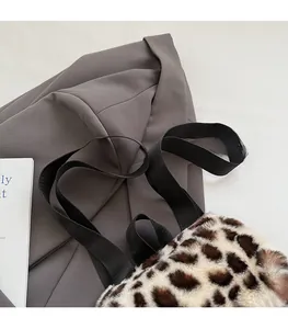 Détail du sac cabas en peluche léopard avec des bretelles noires en nylon tissé