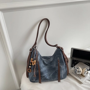Close-up of vintage denim texture shoulder bag with leather tassel and bead accents
