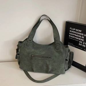 Dettaglio borsa tote retrò verde scuro con tasche laterali e tracolla lunga regolabile