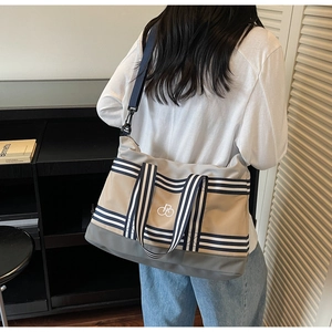 Détail du sac cabas multicolore avec bandoulière réglable et logo brodé en blanc
