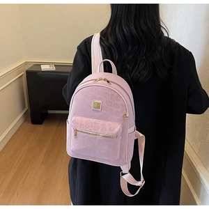 Detailed close-up of pink leopard print backpack with gold zipper and suede texture