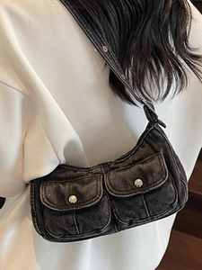 Vintage black denim half-moon shoulder bag with flap pockets and metal hardware details