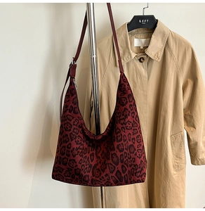 Detail of burgundy leopard print hobo bag showing faux suede texture and silver metal buckle