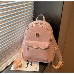 Detail of light pink leopard embossed backpack with golden zippers and square logo plaque