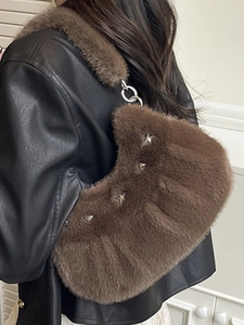 Sac bandoulière en fausse fourrure marron avec rivets étoiles porté par un mannequin