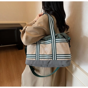 Détail du grand sac cabas en toile kaki avec des sangles rayées vu de l'arrière