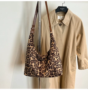 Detail shot of leopard print hobo tote bag featuring a brown leather adjustable shoulder strap