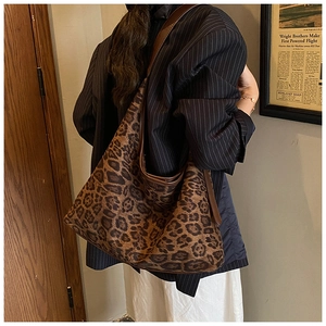 Detail of leopard print tote bag showing large capacity and brown leather trim texture