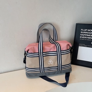 Vue détaillée du sac fourre-tout tricolore avec sangles rayées et logo de vélo