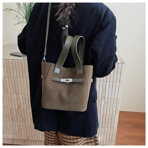 Detailed back view of a dark brown suede bucket bag with olive green leather handles