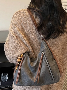 Retro grey canvas tote bag with brown straps and tassel detail shown on model back