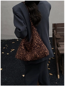 Outdoor shot of a large leopard print tote bag with brown leather trim and retro autumn vibe