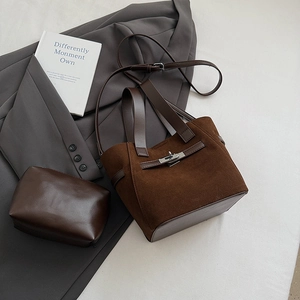 Detail of dark brown suede bucket bag with silver metal clasp and matching leather pouch