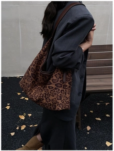 Chic leopard print hobo tote bag held by a model in a stylish autumn outdoor setting