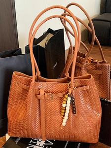 Brown woven leather tote bag with fishtail knit pattern and beaded charm accessory