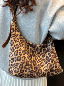 Large leopard print tote bag with brown leather shoulder strap in a stylish hobo design