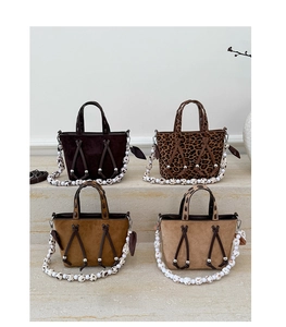 Detail of trendy leopard print and solid suede bucket bags with beaded decorative straps