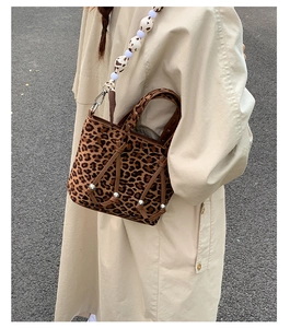 Detailed view of leopard print bucket bag featuring a beaded strap and leather ties