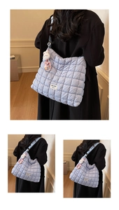 Detail of light blue quilted tote bag with cute plush bunny charm and beaded chain