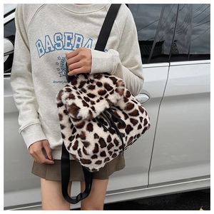 Détail d'un sac à dos en peluche à motif léopard avec des bretelles en nylon et cordon de serrage
