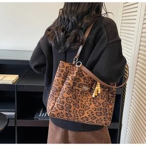 Detail view of leopard print tote bag with wooden bead charm and FASHION label