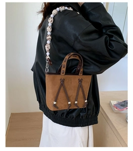 Detail of leopard print beaded strap and studded suede brown bucket bag for women