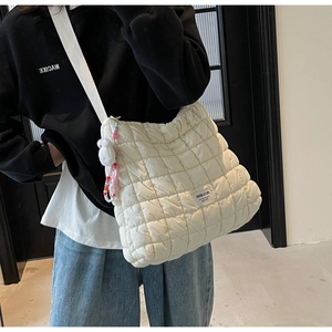 Detail of white quilted cloud bag featuring soft texture and a cute rabbit charm accessory