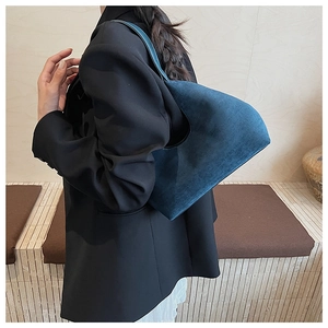Detailed texture of navy blue suede hobo shoulder bag styled with black blazer outfit