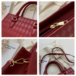 Close-up of diamond quilted texture and golden hardware on red faux leather tote bag