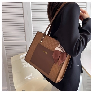 Detail of checkered tote bag with leather pocket and decorative leopard print silk scarf
