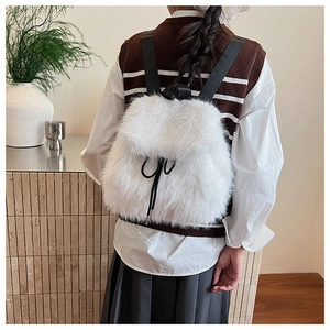 Détail du sac à dos en peluche blanche montrant la texture de fausse fourrure et cordon noir