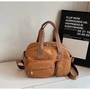 Detail of tan nylon multi-pocket crossbody bag showing waterproof fabric and zippers