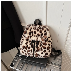 Détail du sac à dos en peluche léopard avec cordon sur une valise argentée
