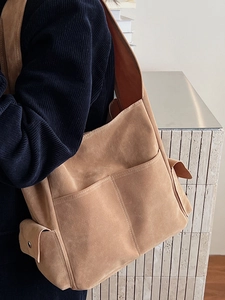 Grand sac cabas en daim camel avec plusieurs poches porté par un mannequin en intérieur