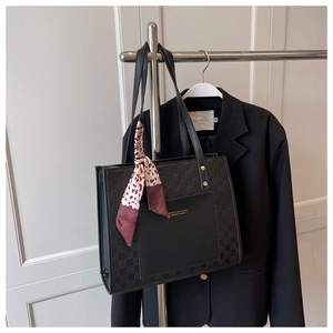 Detail of black tote bag with checkered embossing and stylish leopard print scarf