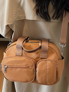 Brown canvas messenger bag with dual zipper pockets and adjustable wide shoulder strap