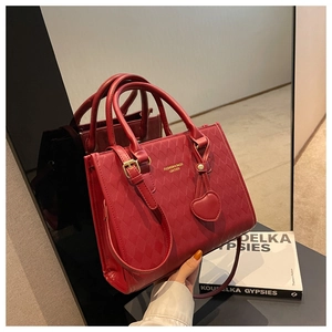 Detailed close-up of the red quilted leather texture and gold hardware on this tote bag