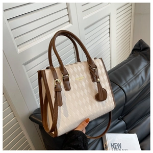 Detail of quilted beige pattern with brown leather trim and fashion bags leather text