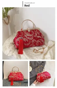 Dettaglio della borsa in seta rossa con ricami floreali dorati ed elegante nappa decorativa