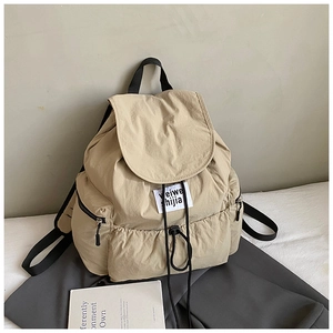 Détail du sac à dos kaki en nylon lavé avec fermeture à cordon et poches latérales