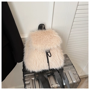 Détail du sac à dos en peluche beige avec cordon noir et texture en fausse fourrure