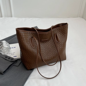 Close-up of brown woven faux leather tote bag on a stylish business background