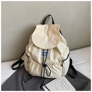 Vue détaillée du sac à dos blanc crème avec fermeture à cordon et tissu texturé