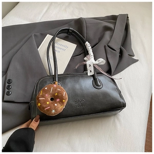 Detail of black matte PU leather boston bag with plush pendant and lace ribbon decor