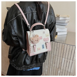 Detail of cute white and pink backpack with plush bear and decorative embroidery patches