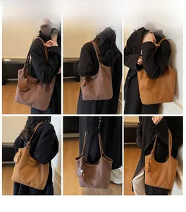 Dettaglio della borsa tote in pelle scamosciata retrò con materiale e ciondolo a foglia